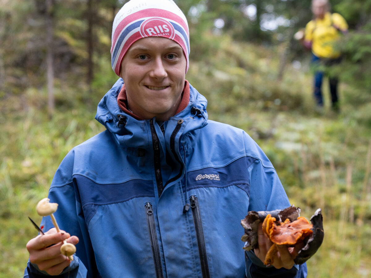 Gutt i skogen med sopp i hendene.